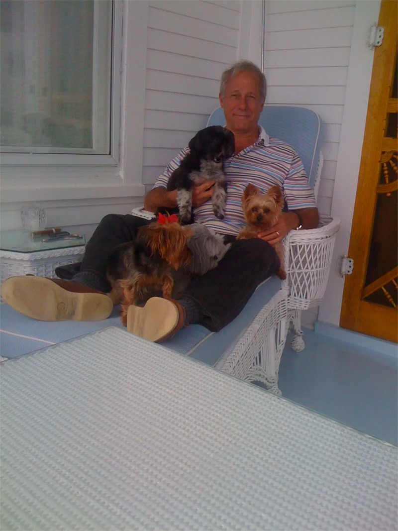 John smiling and holding his dogs